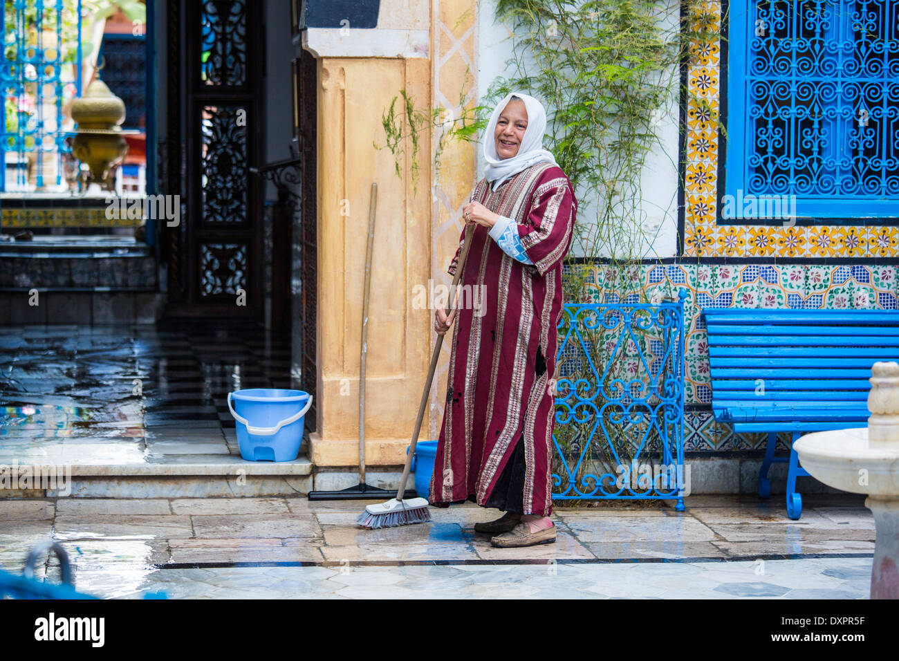 Woman sweeping un étage de Sidi Bou Saïd, Tunisie Banque D'Images