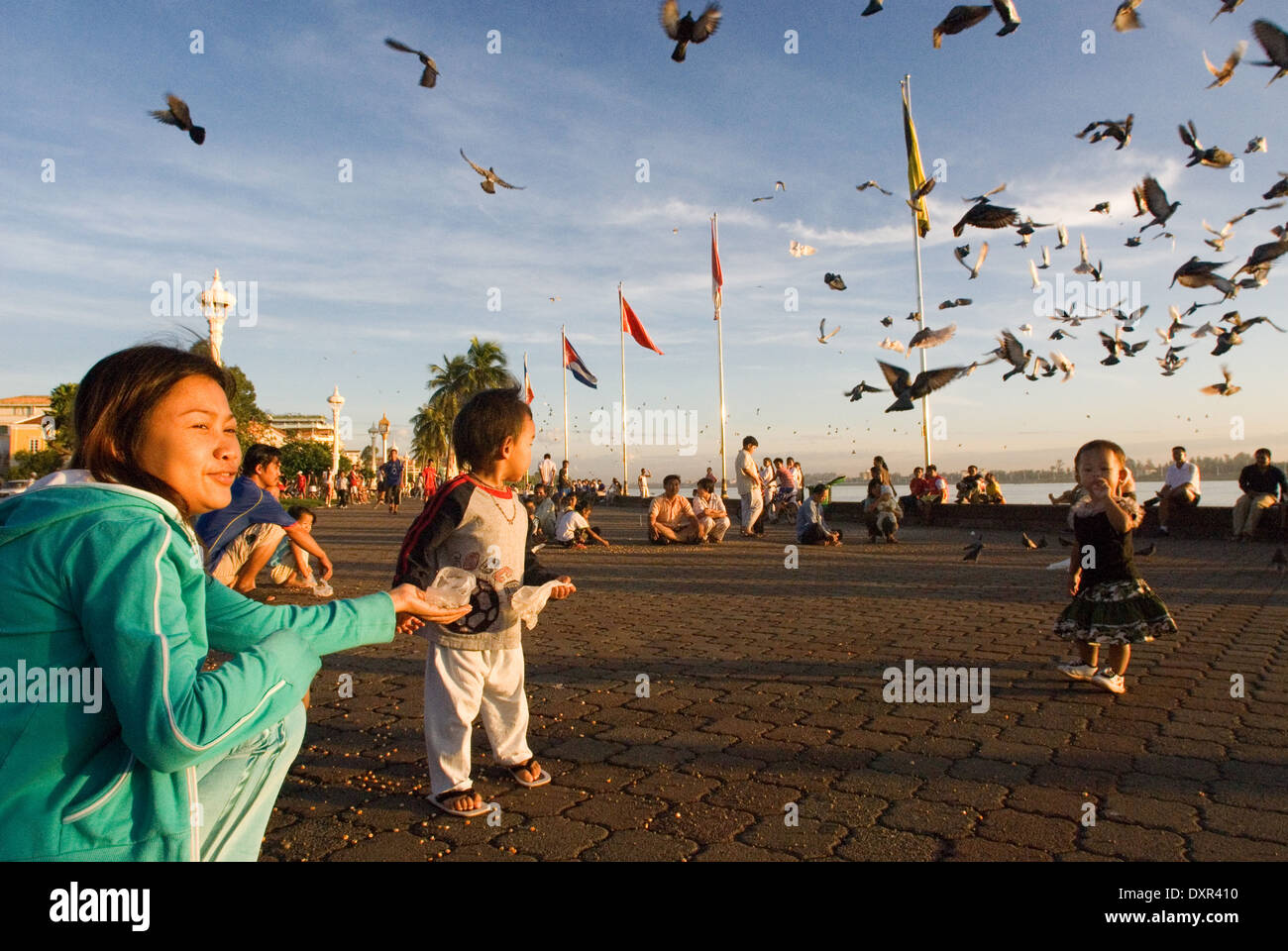 Mère et fille se nourrir les pigeons près du lac Tonlé Sap. Phnom Penh. Peuple Khmer sont le groupe ethnique dominant au Cambodge Banque D'Images