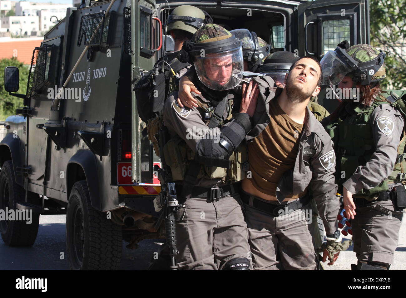 Ramallah, Palestinien. Mar 28, 2014. Des soldats israéliens aidant soldat après qu'il a été blessé par une pierre dans sa main dans Silwad, près de Ramallah, en Cisjordanie, le 28 mars 2014. Un Palestinan arrestation et cinq Palestiniens ont été blessés par balles en caoutchouc et des gaz lacrymogènes, et, au cours de l'vendredi des affrontements entre manifestants palestiniens du village de Silwad, près de Ramallah et l'armée israélienne. © Museitef NurPhoto Abdalkarim //ZUMAPRESS.com/Alamy Live News Banque D'Images