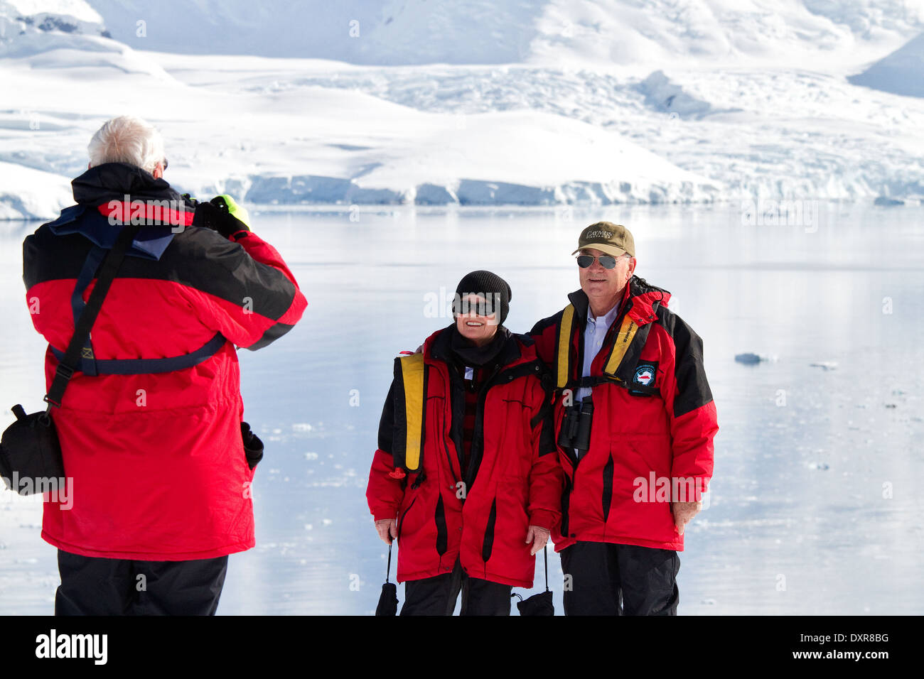 Les touristes de croisière antarctique sur posent pour l'appareil photo en face du magnifique paysage de l'Antarctique et des glaciers de l'iceberg. Banque D'Images