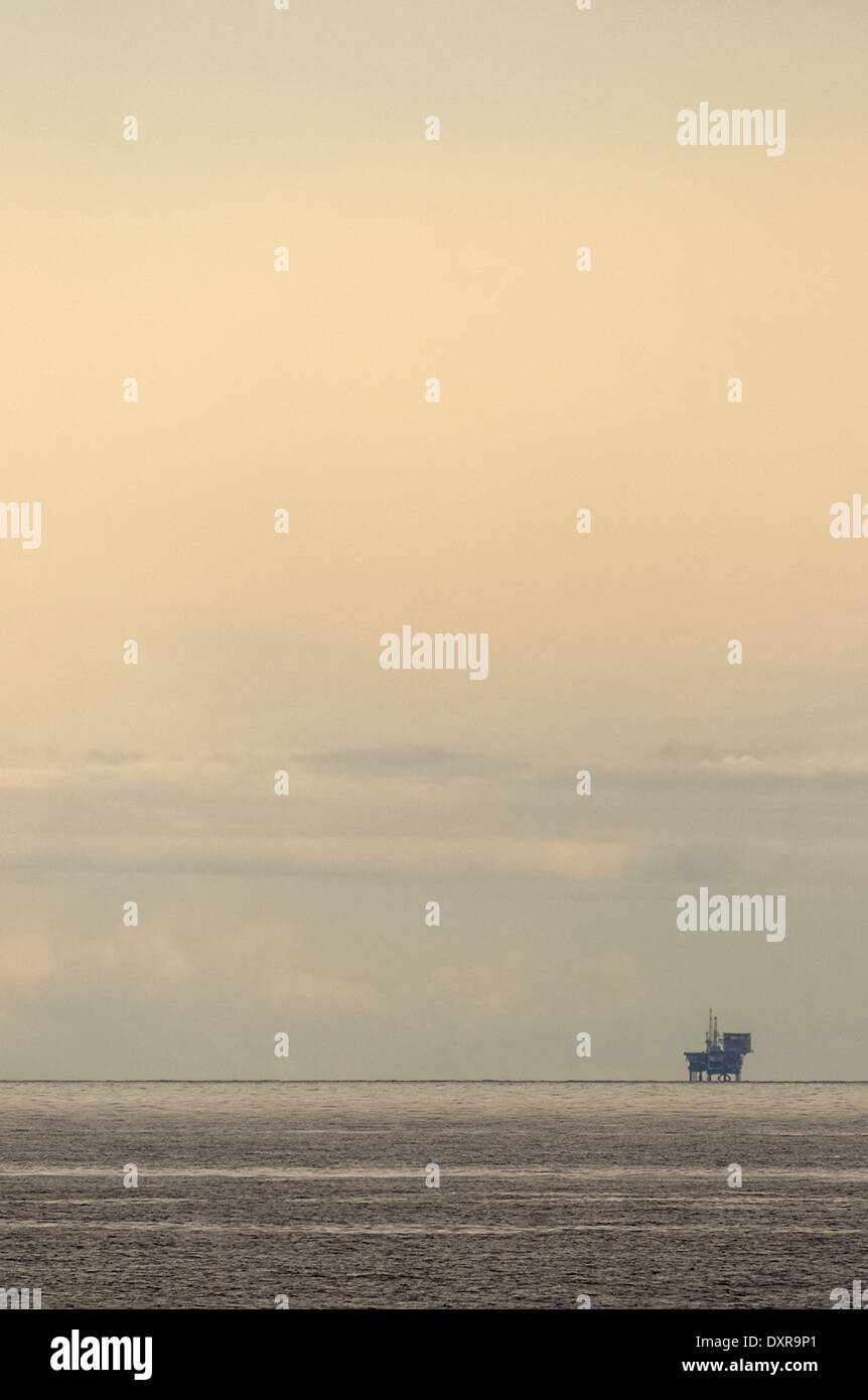 Seule l'huile écossais / gaz rig loin à l'horizon contre un ciel voilé ciel du soir. Banque D'Images