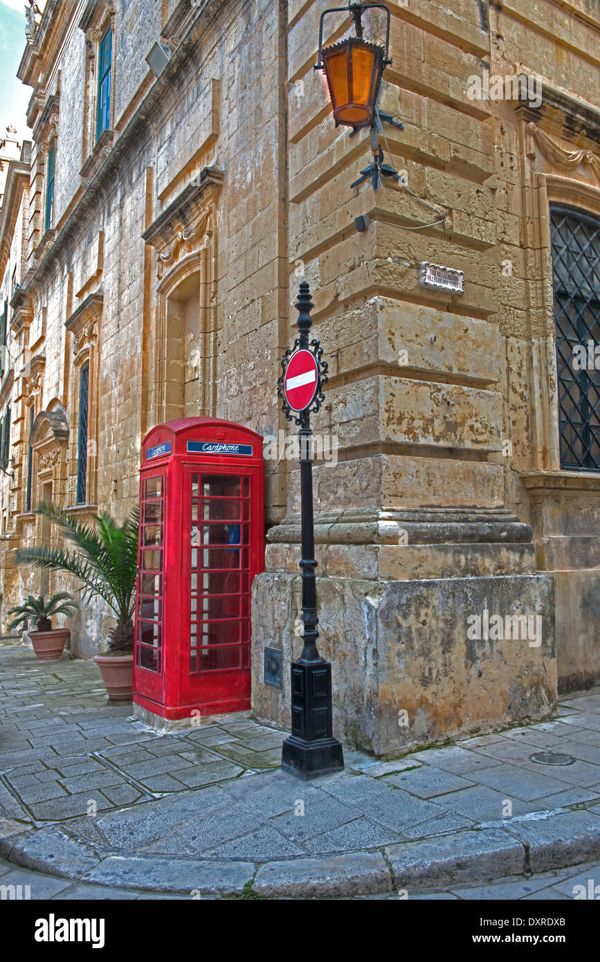 Une boîte de téléphone rouge à côté d'une entrée Pas de signer à Saint Paul's Square, Mdina, communément appelé "La ville silencieuse. Malte. Banque D'Images