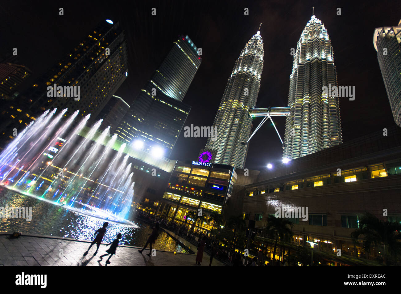 Le centre de Kuala Lumpur la nuit avec des fontaines et des enfants au premier plan et les Tours Petronas tower dans l'arrière-plan Banque D'Images