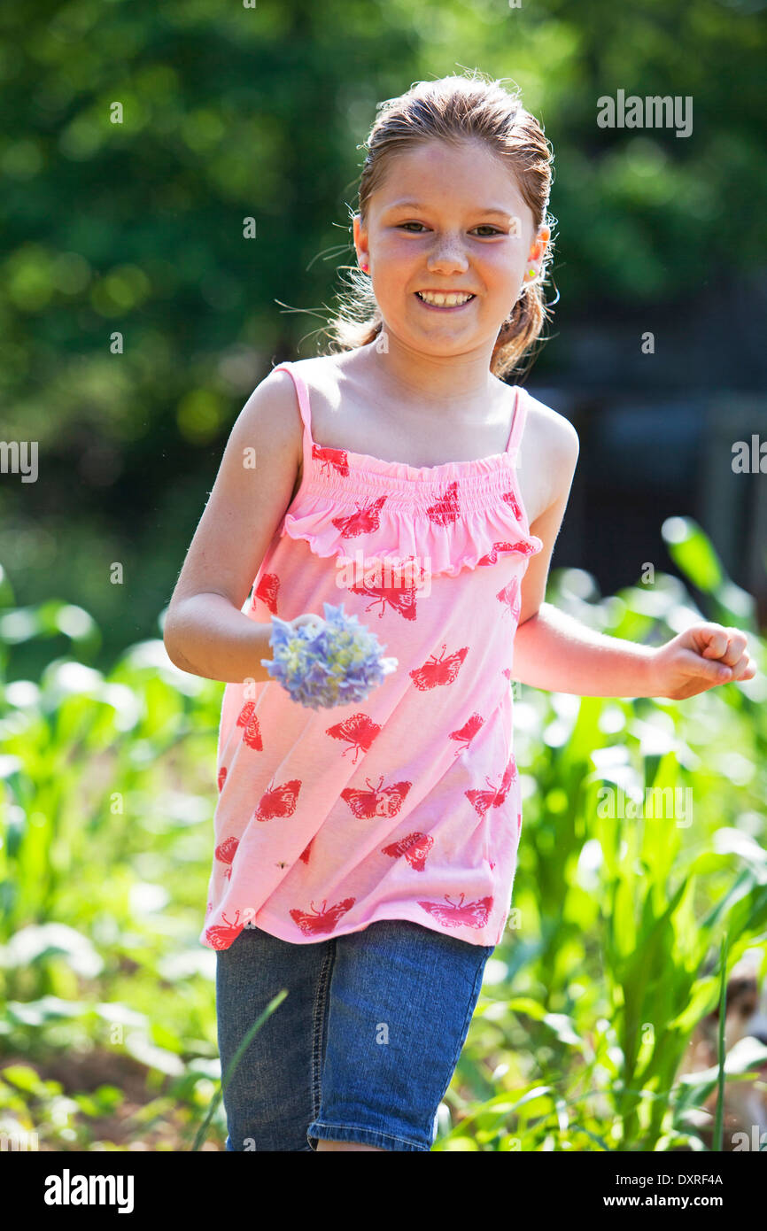 Jeune fille courir à travers un champ agricole Banque D'Images