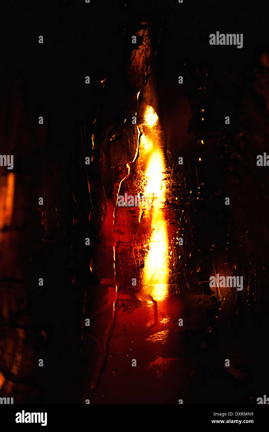 La combustion de la bougie dans un verre humide closeup Banque D'Images