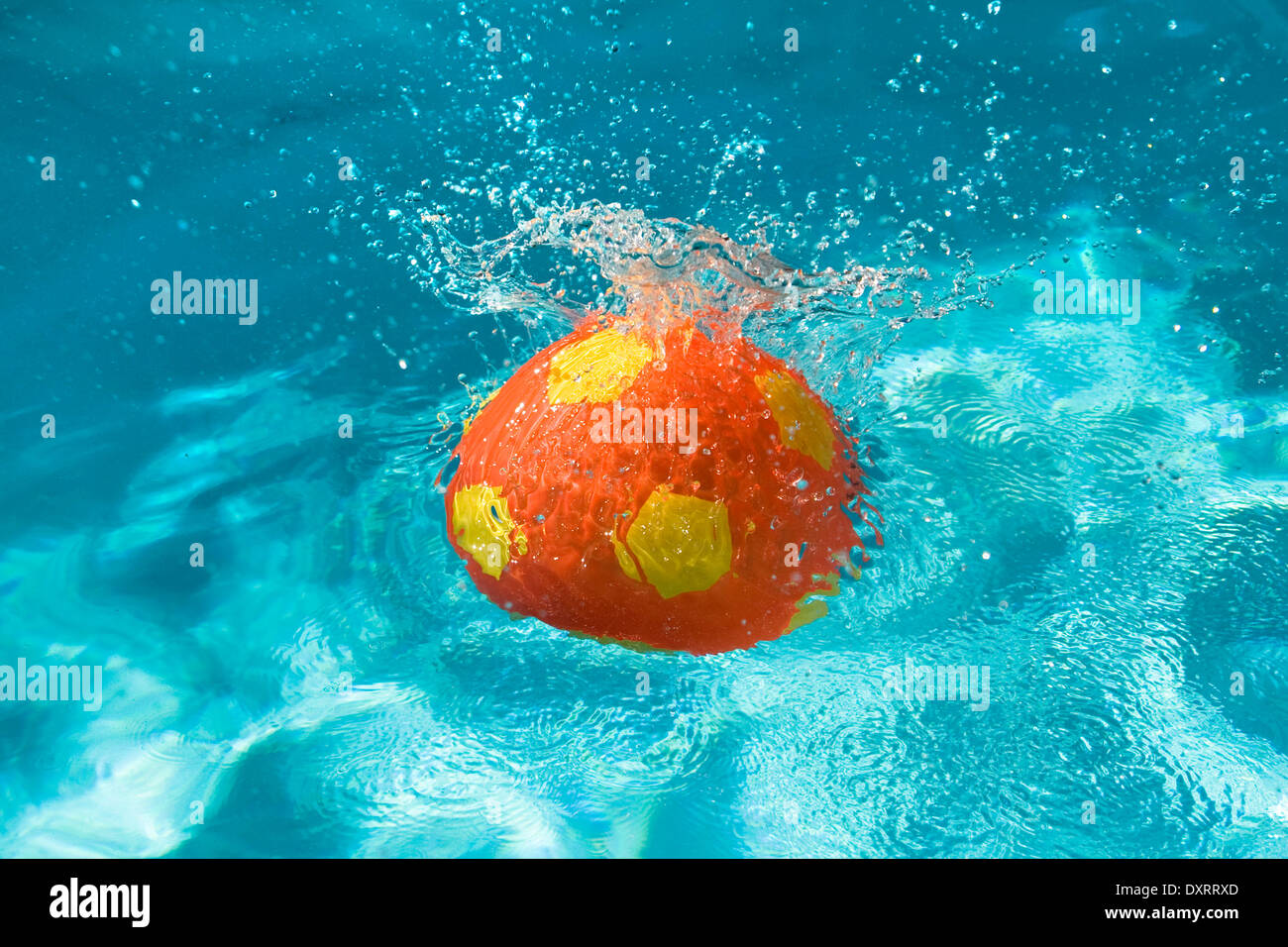 Ballon de plage s'éclabousser dans une piscine. Banque D'Images