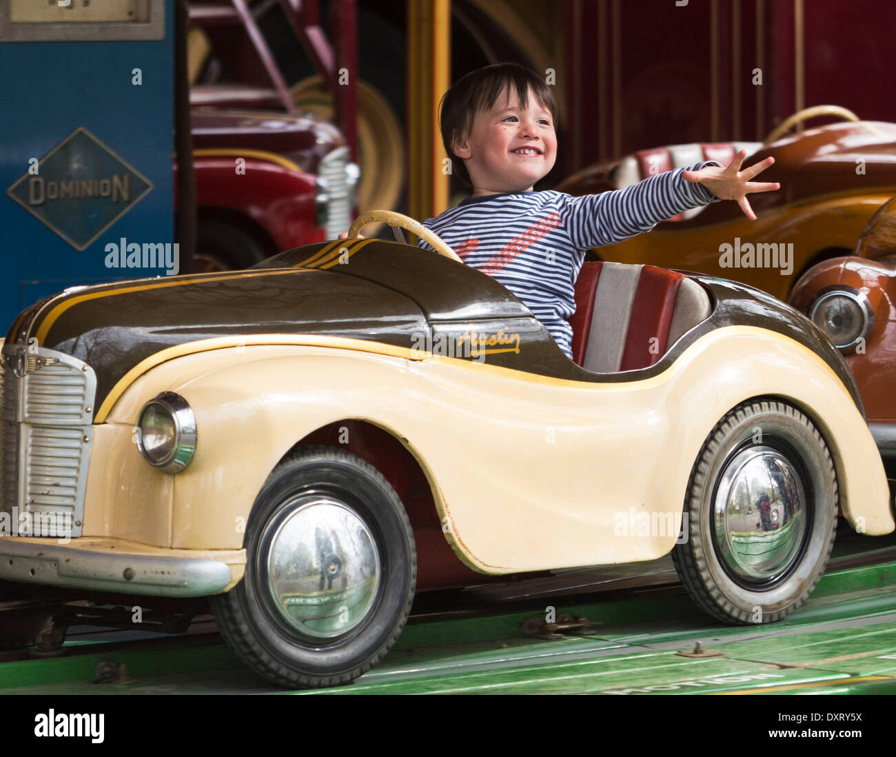 London, UK . 30Th Mar, 2014. L'enfant jouit d'un ride d'une des voitures à Austin les Carter juste à vapeur, Battersea Park, Londres, Royaume-Uni, le dimanche, 30 mars, 2014. Carters Steam Fair est une ancienne fête foraine que chaque année, depuis 1977, voyages dans les villes et villages tout au long de Londres, le Home Counties et au-delà avec vintage poids lourds et traditionnelles du showman de wagons. La famille Carter de maintenir une collection de manèges et sidestalls, allant en date de la fin du xixe siècle aux années 1960. Credit : Cecilia Colussi/Alamy Live News Banque D'Images