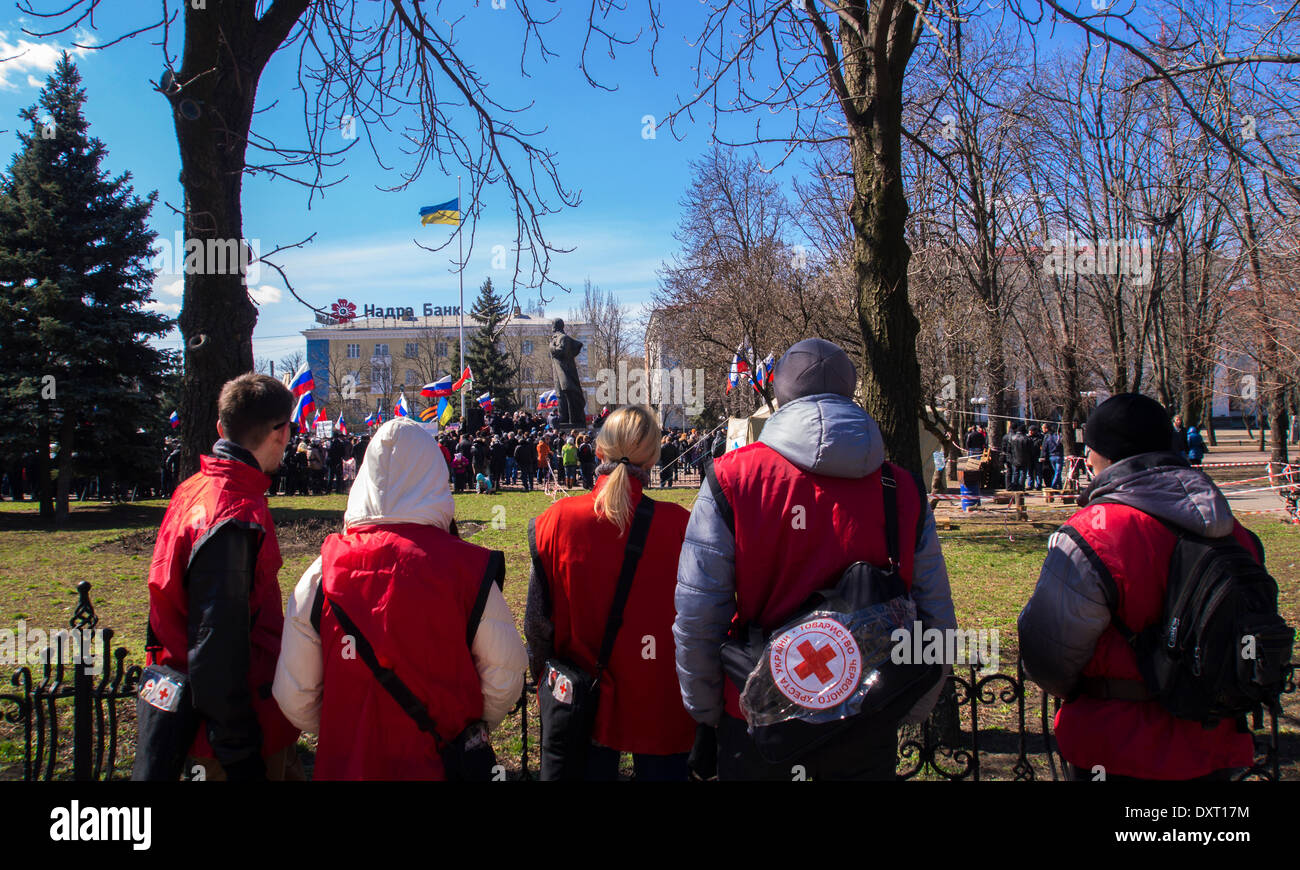 Kiev, UKRAINE - le 30 mars 2014 : Croix Rouge personnel prêt à aider les manifestants. Lugansk rallye séparatistes recueillis seulement environ 500 personnes. Tous d'entre eux ont appuyé les appels à se joindre à la Russie et de ne pas reconnaître le pouvoir à Kiev.Les gens qui se déclarent comme des combattants contre le fascisme applaudi le discours anti-Semit homme qui s'est présenté comme un mineur de l'Krasnyy Luch Banque D'Images