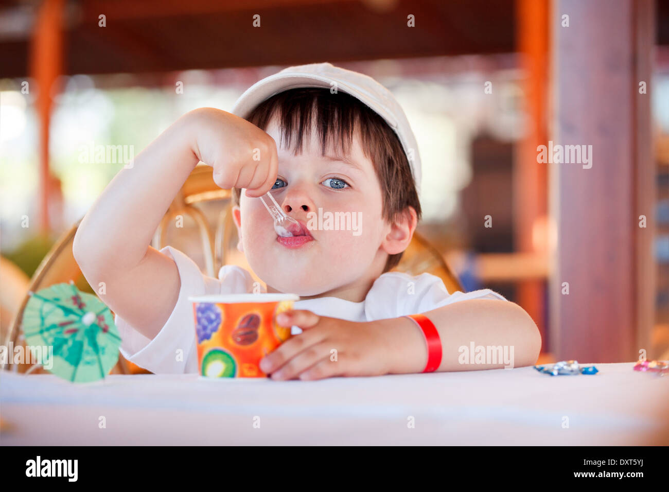 Cute little boy eating ice cream au café à l'intérieur Banque D'Images