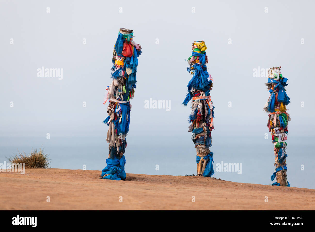 Poteaux en bois avec des rubans colorés (jouer rôle important dans le chamanisme) sur l'île d'Olkhon, le lac Baïkal, Sibérie, Russie Banque D'Images