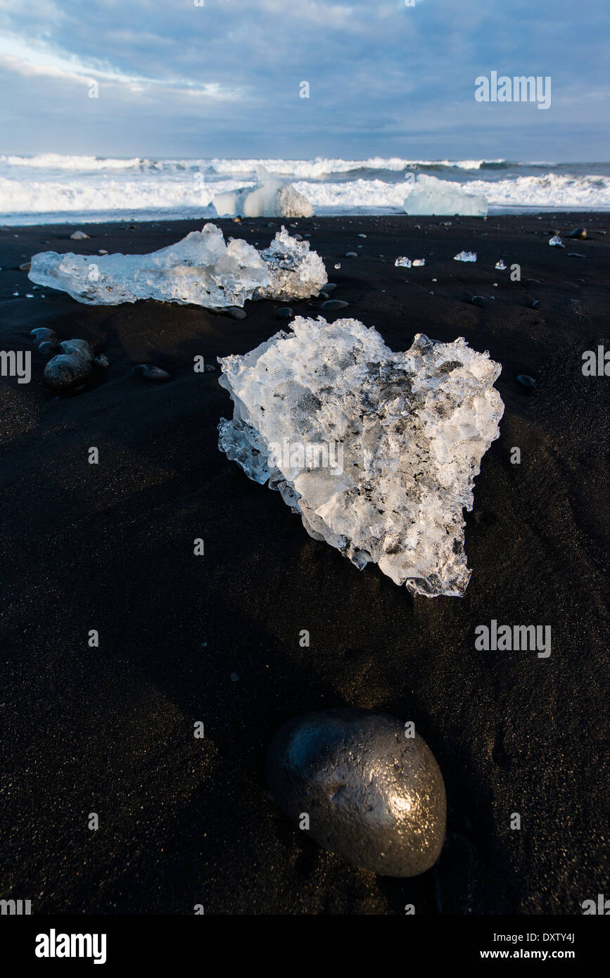 Packs de glace éjectée dérivé du glacier de Vatnajokull sont renvoyés par l'océan Atlantique à la plage de Jokullsarlon, Islande Banque D'Images