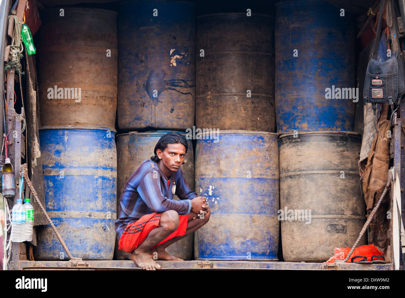 Jeune homme et de barils de carburant au port de Yangon, Myanmar Banque D'Images