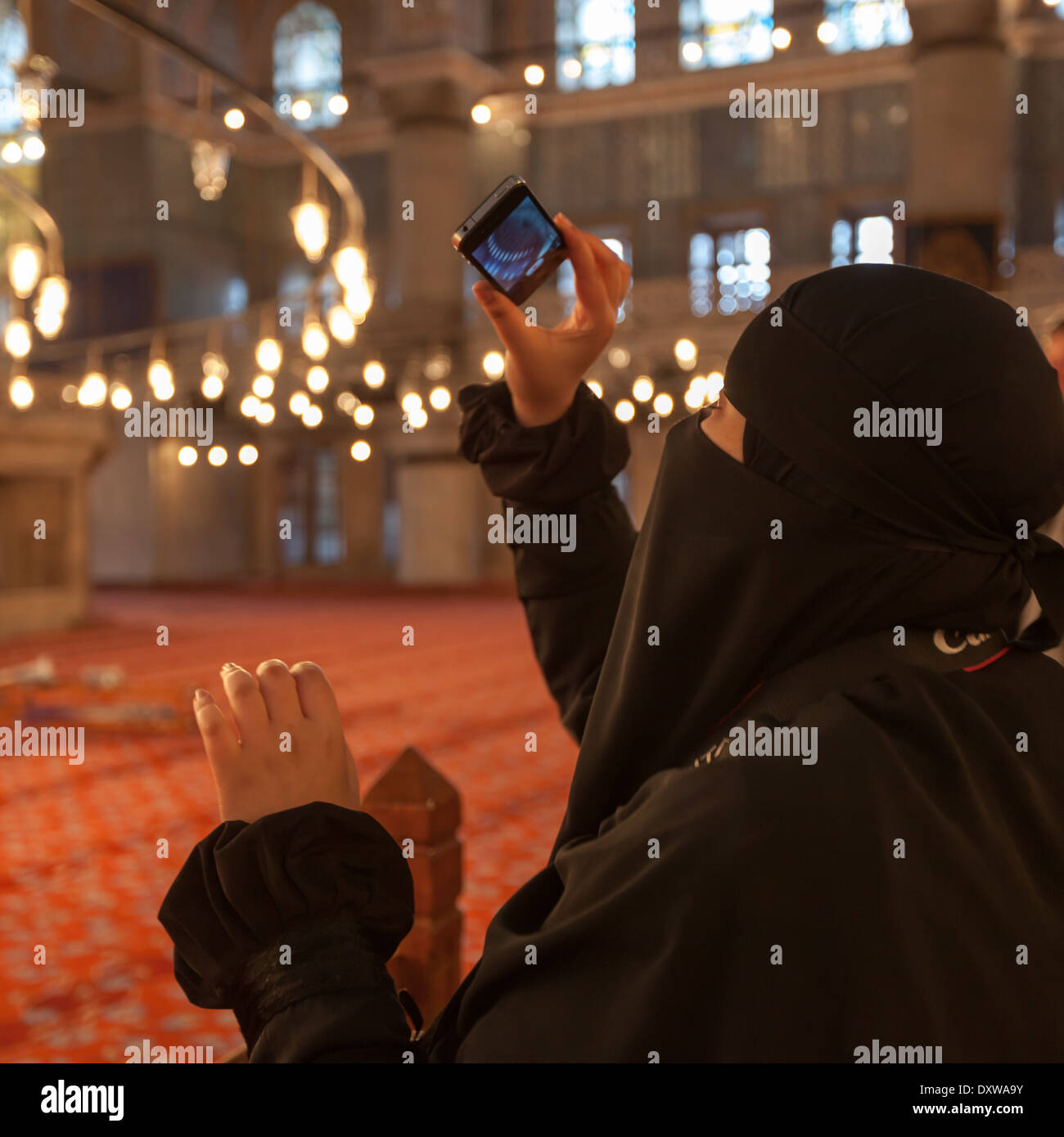 Femme niqab voilée prenant une photo dans la mosquée bleue, Istanbul Banque D'Images