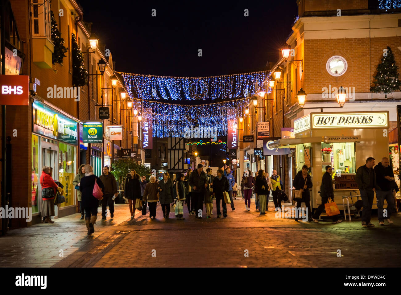 Les acheteurs de Noël dehors tard la nuit dans la ville de Chesterfield illuminé avec des décors et des lumières Derbyshire Banque D'Images