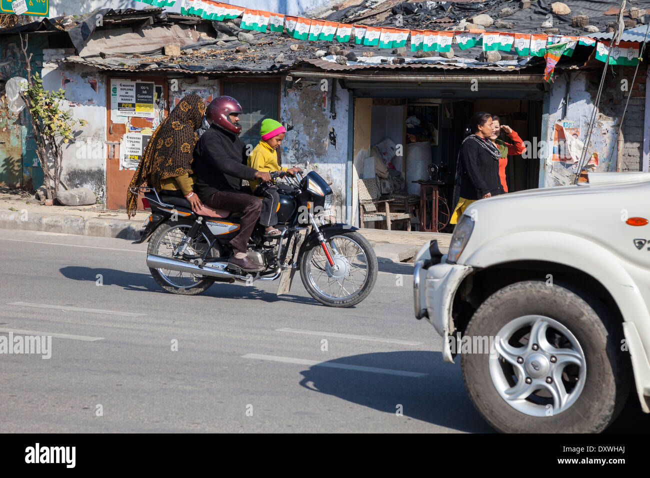 L'Inde, Dehradun. La famille sur une moto--casque pour l'homme, aucune pour la femme ou garçon. Banque D'Images