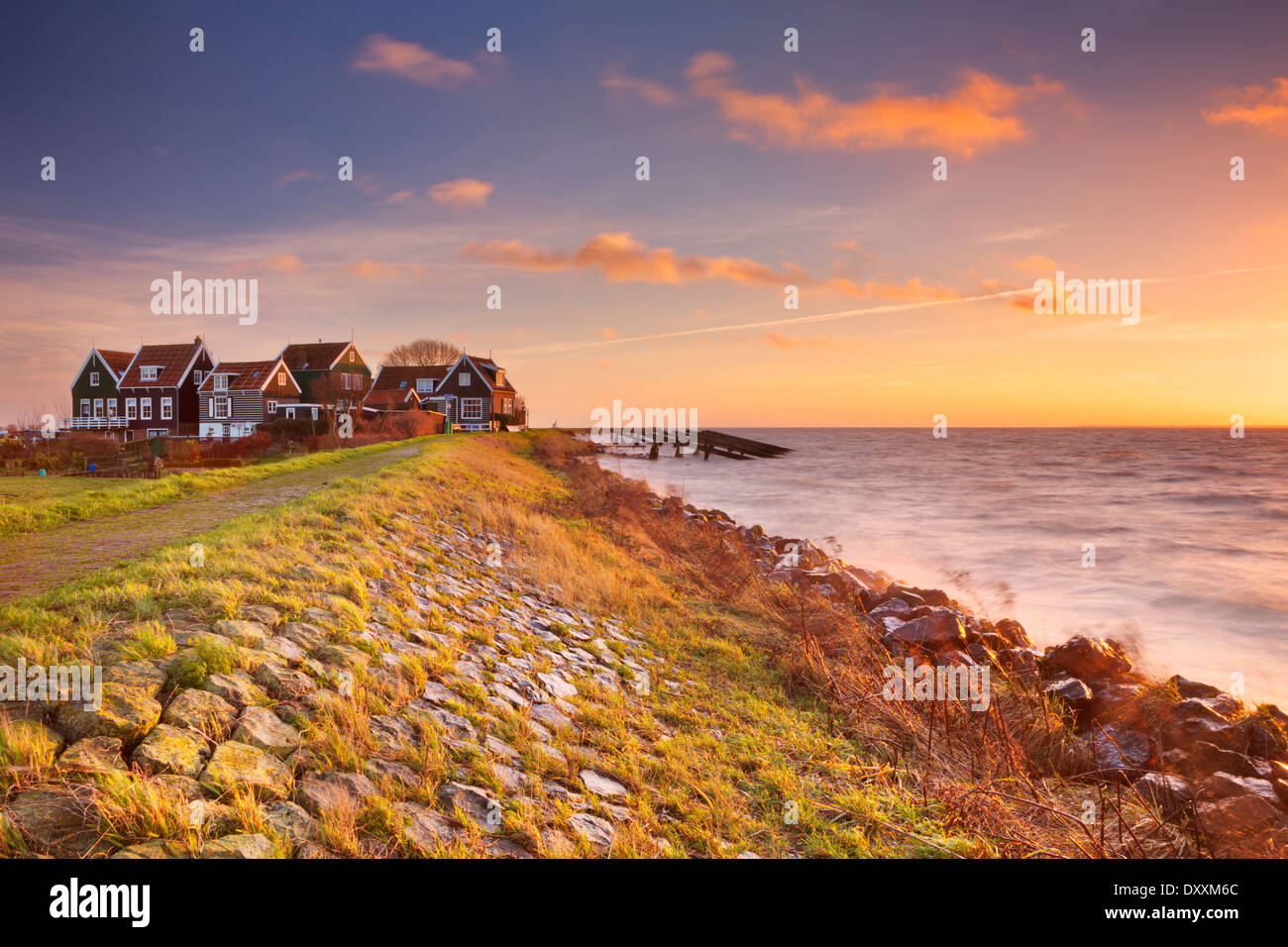 Petit village derrière une digue, photographié sur l'île de Marken dans les Pays-Bas au lever du soleil Banque D'Images
