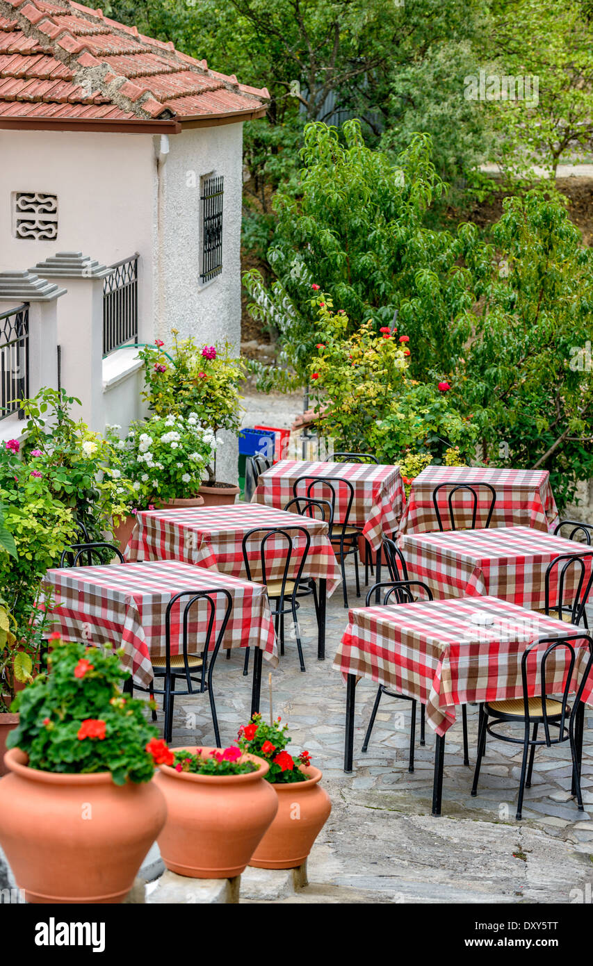 Tables de restaurant sur la terrasse donnant sur la rue avec beau fleurs autour de Banque D'Images