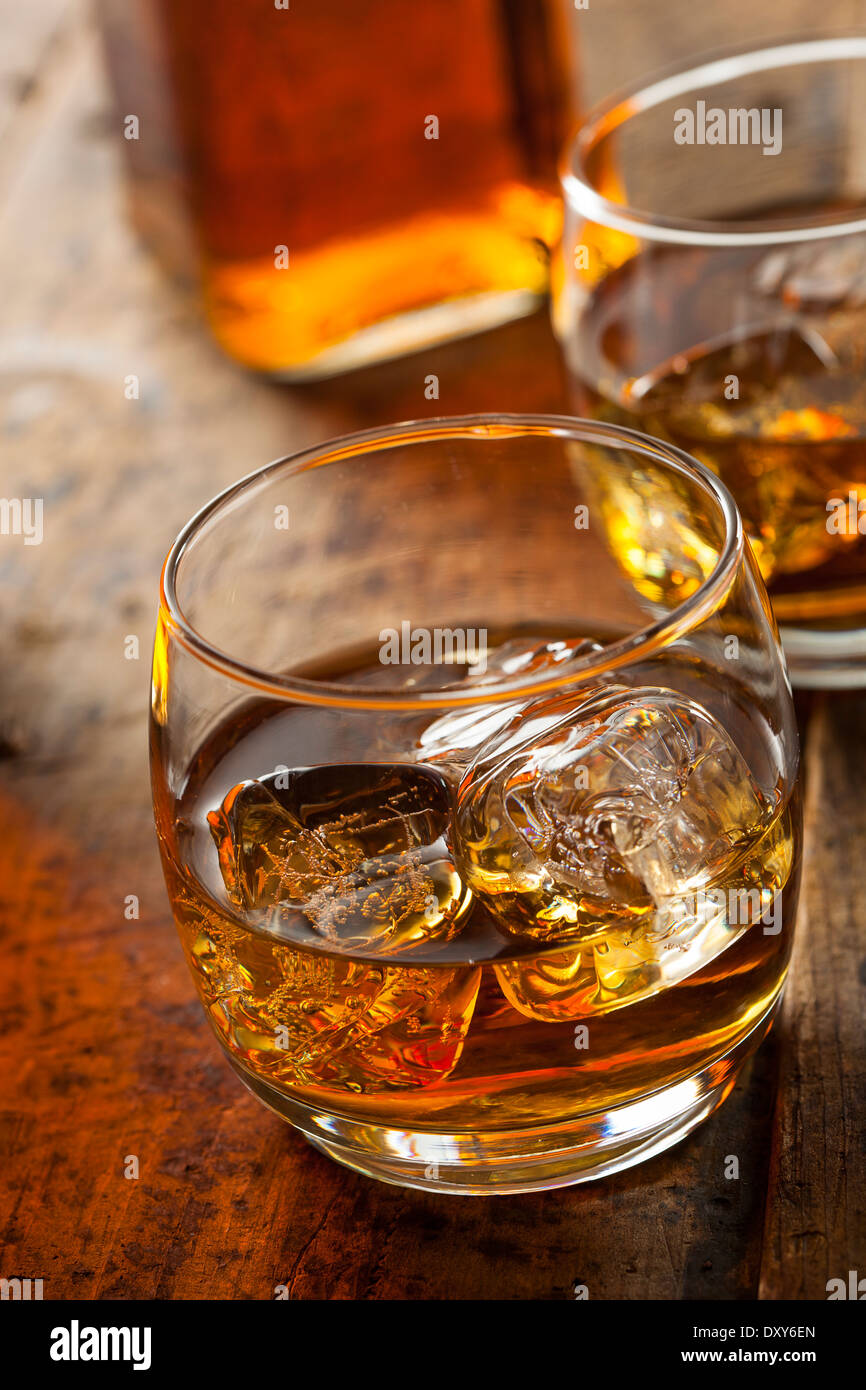 Les Bourbon Whiskey orange dans un verre avec de la glace Banque D'Images