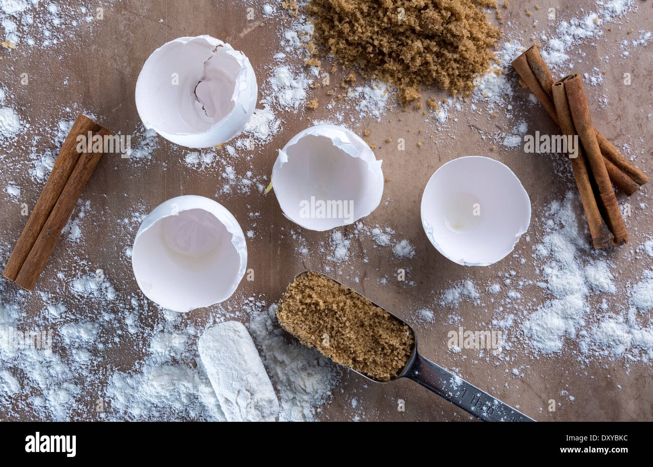 Baker's comptoir avec coquilles cassées, la farine, le sucre brun et les bâtons de cannelle Banque D'Images