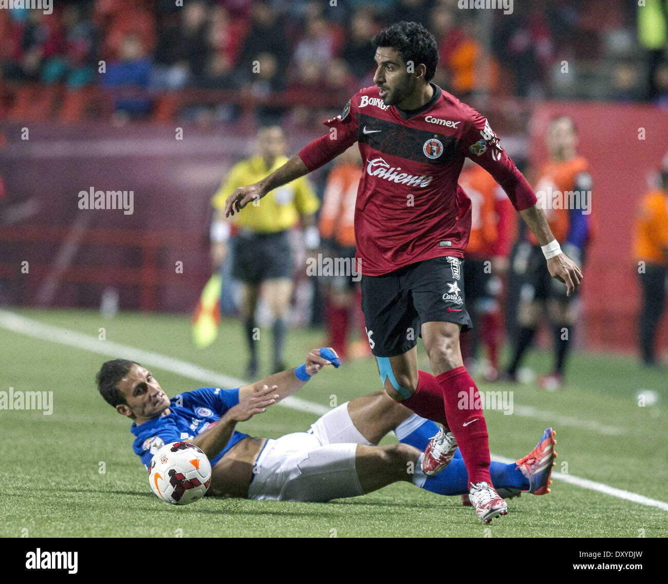 Tijuana, au Mexique. 1er avril 2014. Tijuana's Cristian Pellerano (R) rivalise avec Emmanuel Loeschbor de Cruz Azul pendant leur première étape de la Ligue des Champions de la Concacaf à la demi-finale Stade Caliente à Tijuana, au Mexique, le 1er avril 2014. © Guillermo Arias/Xinhua/Alamy Live News Banque D'Images