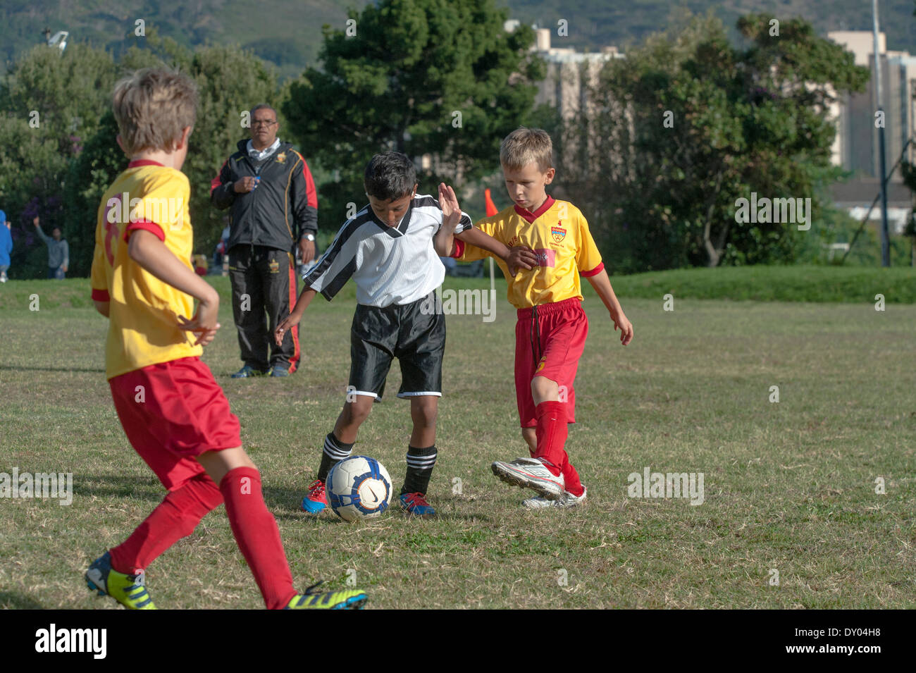 Les joueurs de football d'équipes de jeunes U9 s'attaquer pour gagner la balle, Cape Town, Afrique du Sud Banque D'Images