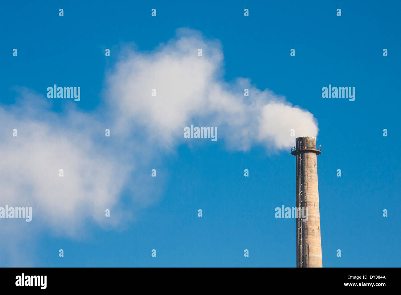 La fumée de cheminée industrielle on blue sky Banque D'Images