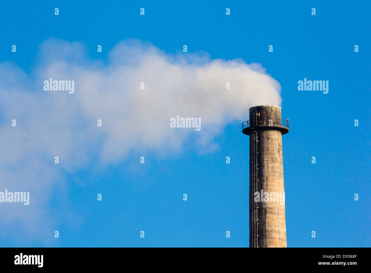 La fumée de cheminée industrielle on blue sky Banque D'Images