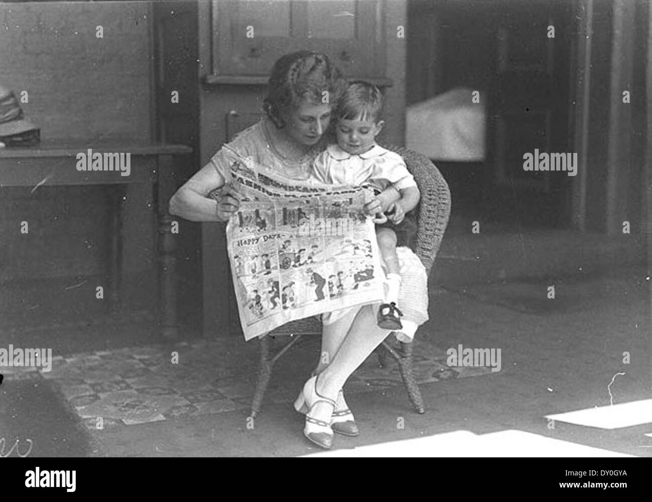 Dans cette image de janvier 1925, la vedette de comédie musicale Dorothy Brunton est vue en train de lire la « Fashion-plate Fanny » de Sid Nicholl dans le journal The Sun, accompagnée d'un petit garçon à l'hôpital Margaret's de Sydney. La photo offre un aperçu de la culture populaire et des médias de l'époque. Banque D'Images