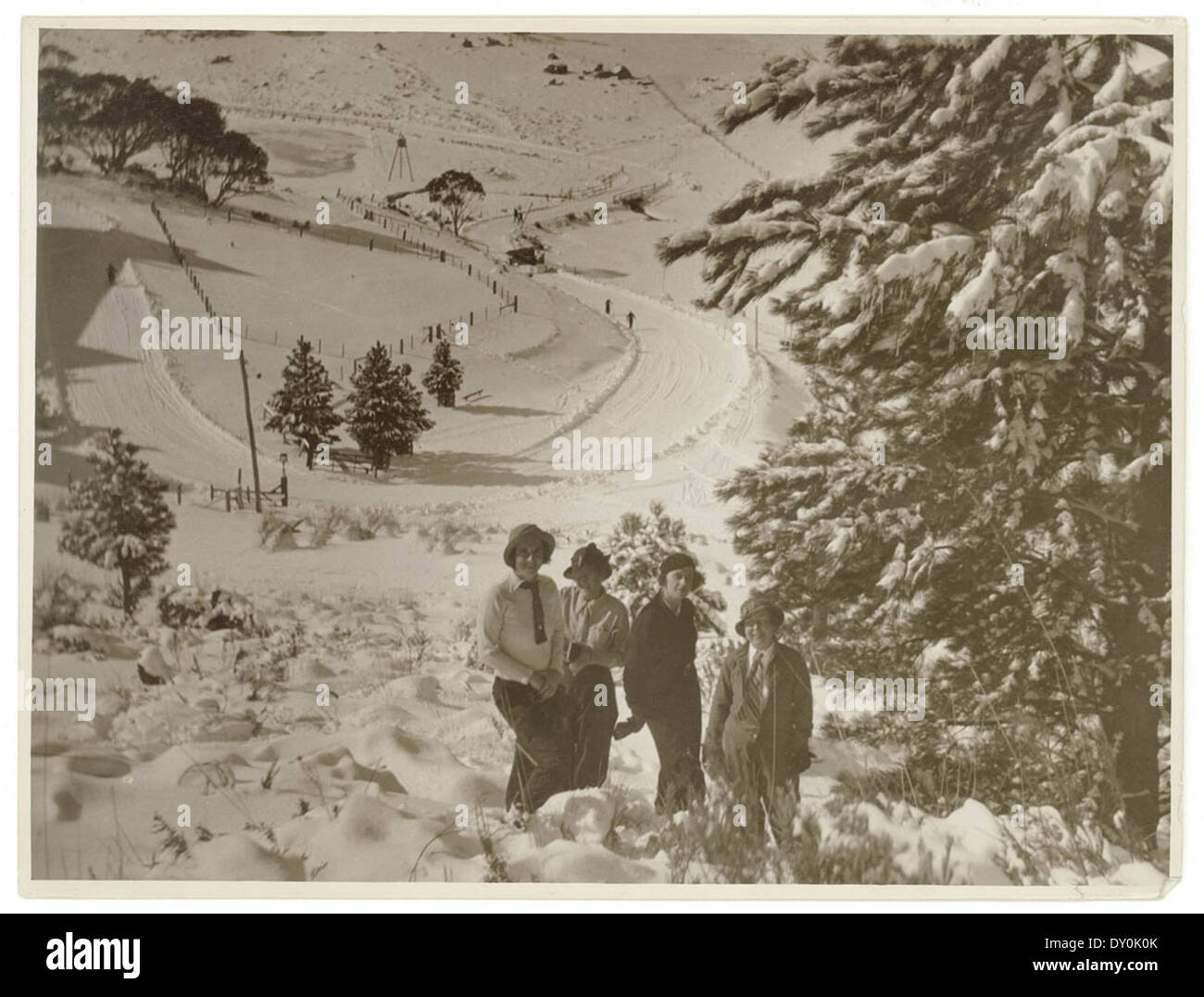 Une photographie des années 1930 par Sam Hood capturant une scène de ski dans les champs de neige. Il reflète la popularité du sport d’hiver à cette époque, mettant en valeur les tenues de ski et les paysages enneigés. Banque D'Images