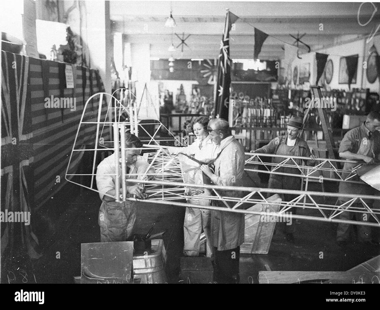 Cette photographie de 1934 montre May Bradford et le designer Jack Jones travaillant sur l'empennage d'un monoplan pour la course aérienne Angleterre-Australie. Capturée par Sam Hood, l'image reflète le développement précoce de l'aviation et l'excitation entourant cette course internationale. Banque D'Images