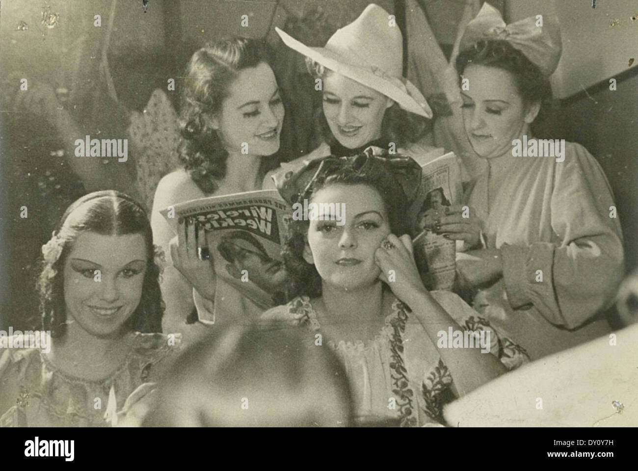 Cette photographie d'environ 1940 montre des artistes femmes à Sydney Reading Wireless Weekly, avec l'image les capturant reflétée dans un miroir. La photo est un aperçu historique du divertissement et des médias de l'époque. Banque D'Images