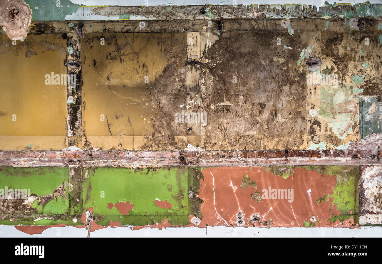 Un vieux mur intérieur avec raccords déposés révélant les couches de peinture et de plâtre. Banque D'Images