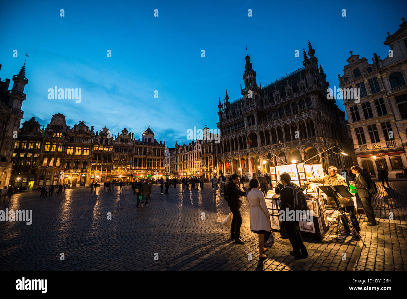Grand-place illuminée la nuit Bruxelles Belgique // BRUXELLES, Belgique — la Grand-place brille sous l'éclairage du soir, mettant en valeur les façades ornées de ses bâtiments historiques. Les détails architecturaux du site classé au patrimoine mondial de l'UNESCO sont éclairés de façon spectaculaire contre le ciel nocturne, mettant en valeur les caractéristiques gothiques et baroques de la place. La place médiévale illuminée est la principale attraction touristique de Bruxelles, attirant les visiteurs pour son spectacle nocturne enchanteur. Banque D'Images