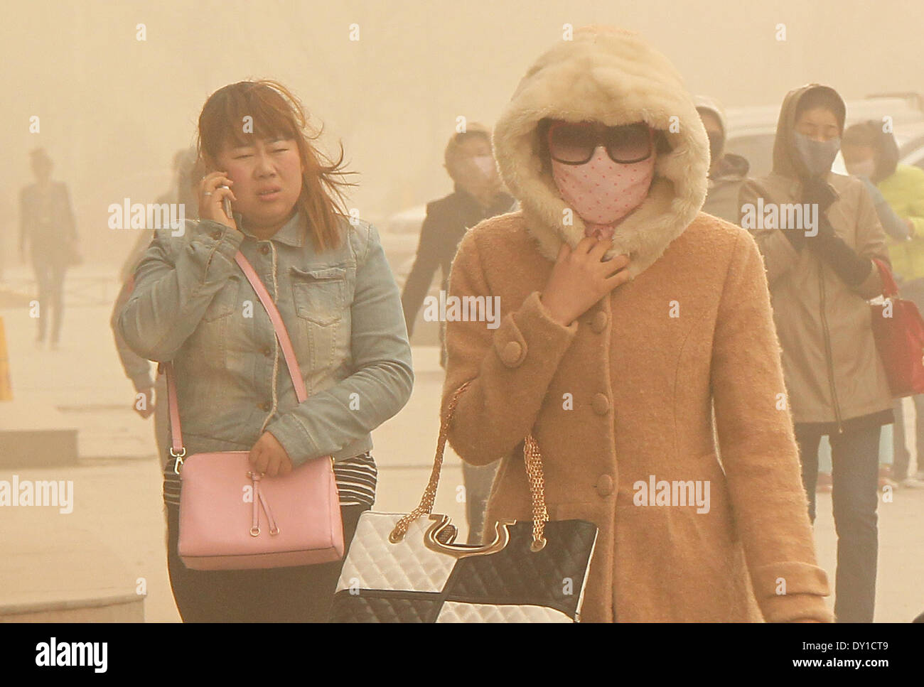 Hami, la Région Autonome Uygur du Xinjiang. 3ème apr 2014. Les piétons marchent dans tempête de Haimi, nord-ouest de la Chine, la Région autonome du Xinjiang Uygur, le 3 avril 2014. Une tempête a frappé la ville de jeudi. Credit : Polat/Xinhua/Alamy Live News Banque D'Images