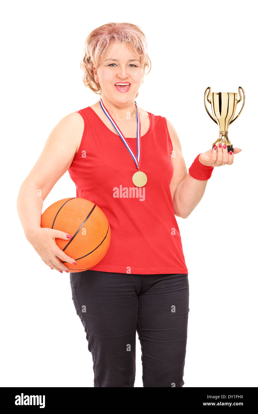 Mature Woman holding trophy et un terrain de basket-ball Banque D'Images