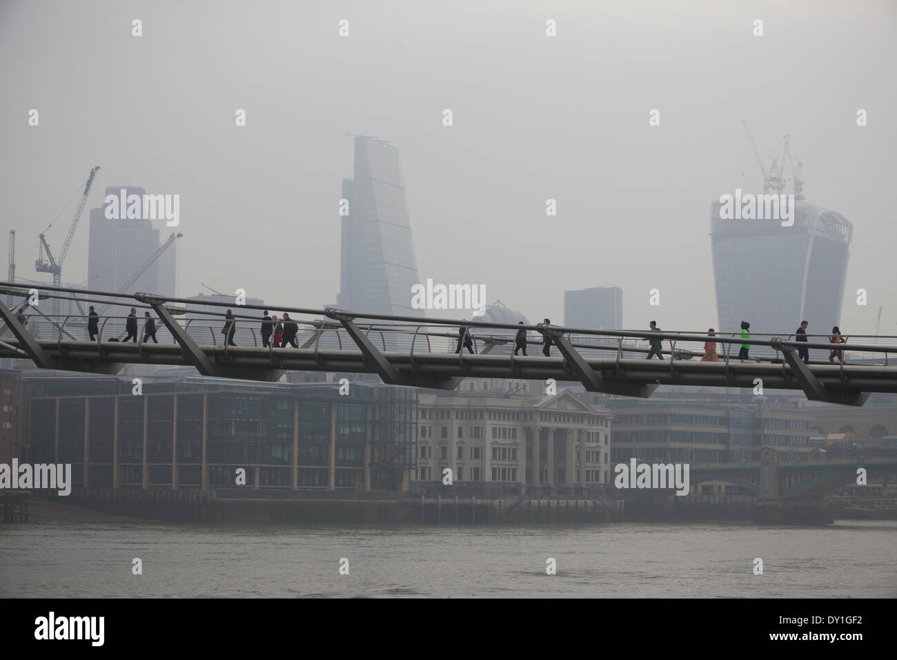 Londres, Royaume-Uni. 3 avril, 2014. Le Smog de Londres : Millennium Bridge, City of London, London, UK Les banlieusards font leur chemin à travers le pont du Millenium avec le quartier des finances dans l'arrière-plan enveloppé dans le smog, tandis que le Smog de Londres, et la poussière rouge balayée du Sahara continuent de causer des niveaux élevés de pollution de l'air dans la capitale. Des dizaines de vols ont été annulés et les gens ont été invités à rester à l'intérieur s'ils souffrent d'asthme ou de maladies du coeur. Crédit : Jeff Gilbert/Alamy Live News Banque D'Images