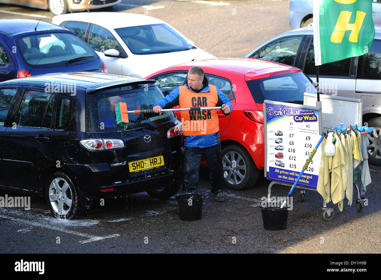 Lavage de voiture, personne laver des voitures dans un parking, UK Banque D'Images