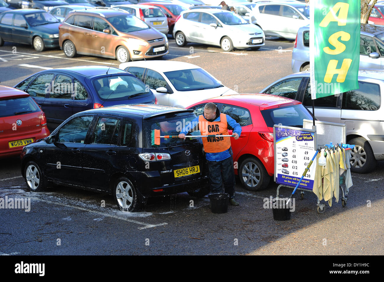 Lavage de voiture, personne laver des voitures dans un parking, UK Banque D'Images