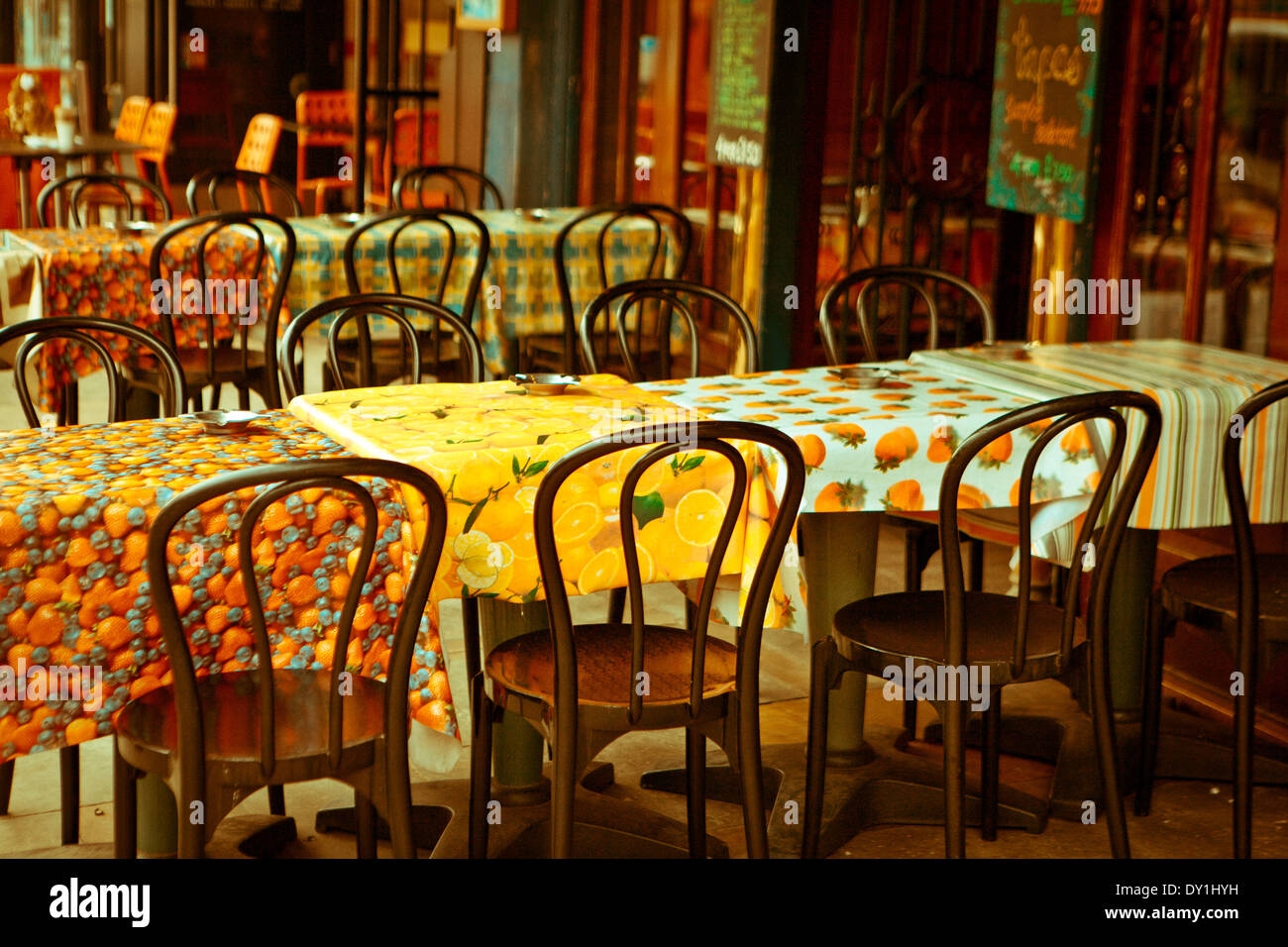 Table et chaises vides à l'extérieur d'un restaurant avec nappes colorées et cendriers Banque D'Images