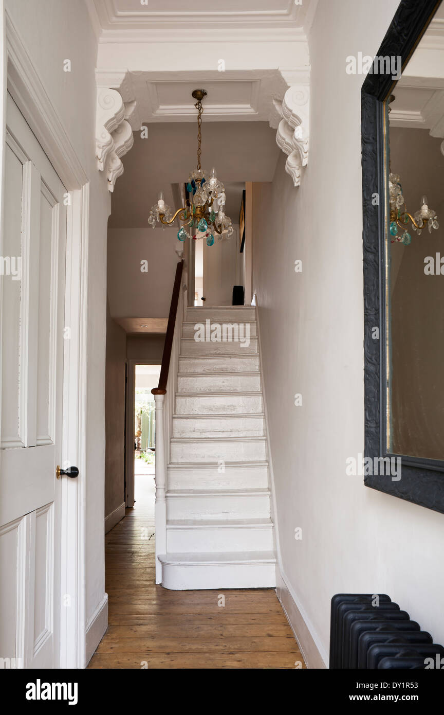 Escalier en bois blanc dans le couloir à encorbellements et blue drop lustre. Banque D'Images