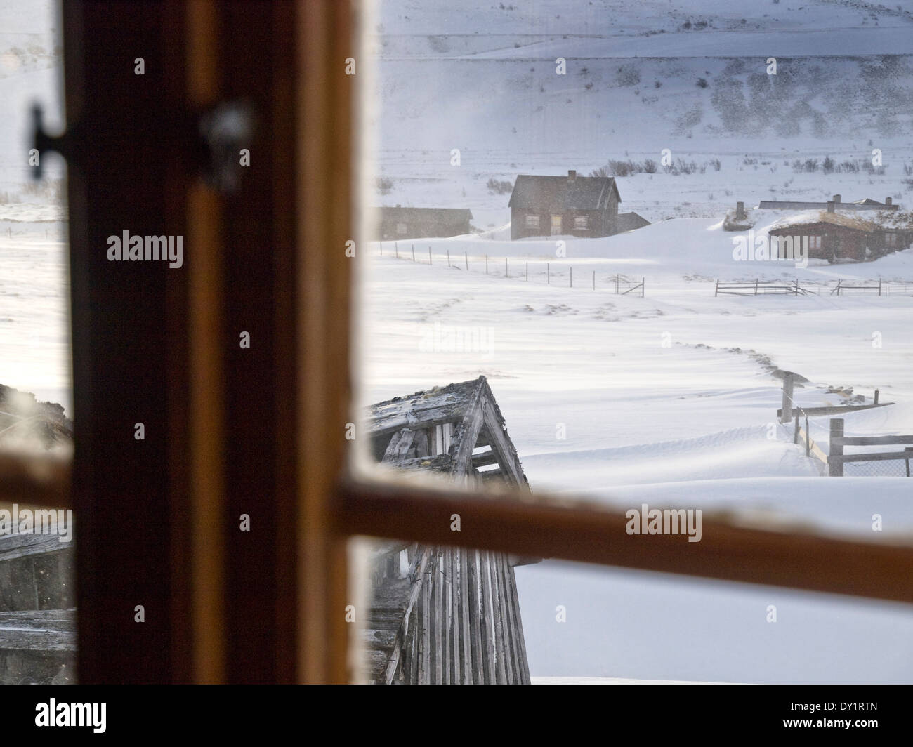 La ferme en montagne en hiver norvégien vu par la fenêtre d'une cabane Banque D'Images