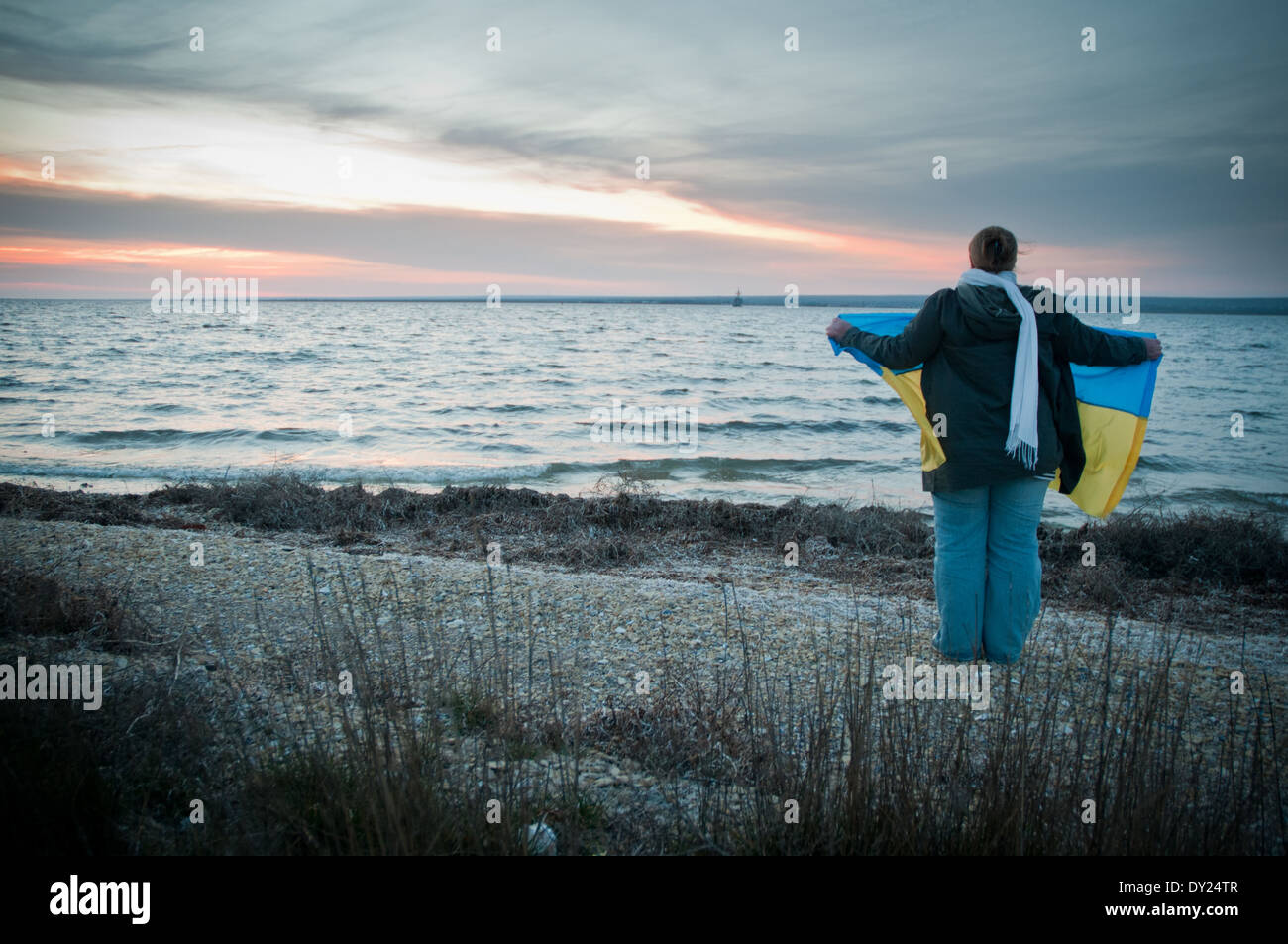 Femme Pro-Ukrainian avec un drapeau national se trouve sur une rive du lac Donuzlav pour soutenir les marines du U311 dragueur de Tcherkassy Banque D'Images