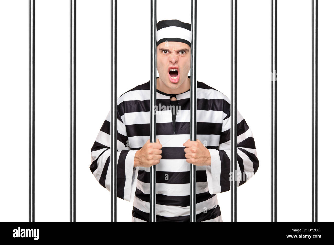 Prisonnier en colère debout derrière les barreaux Banque D'Images