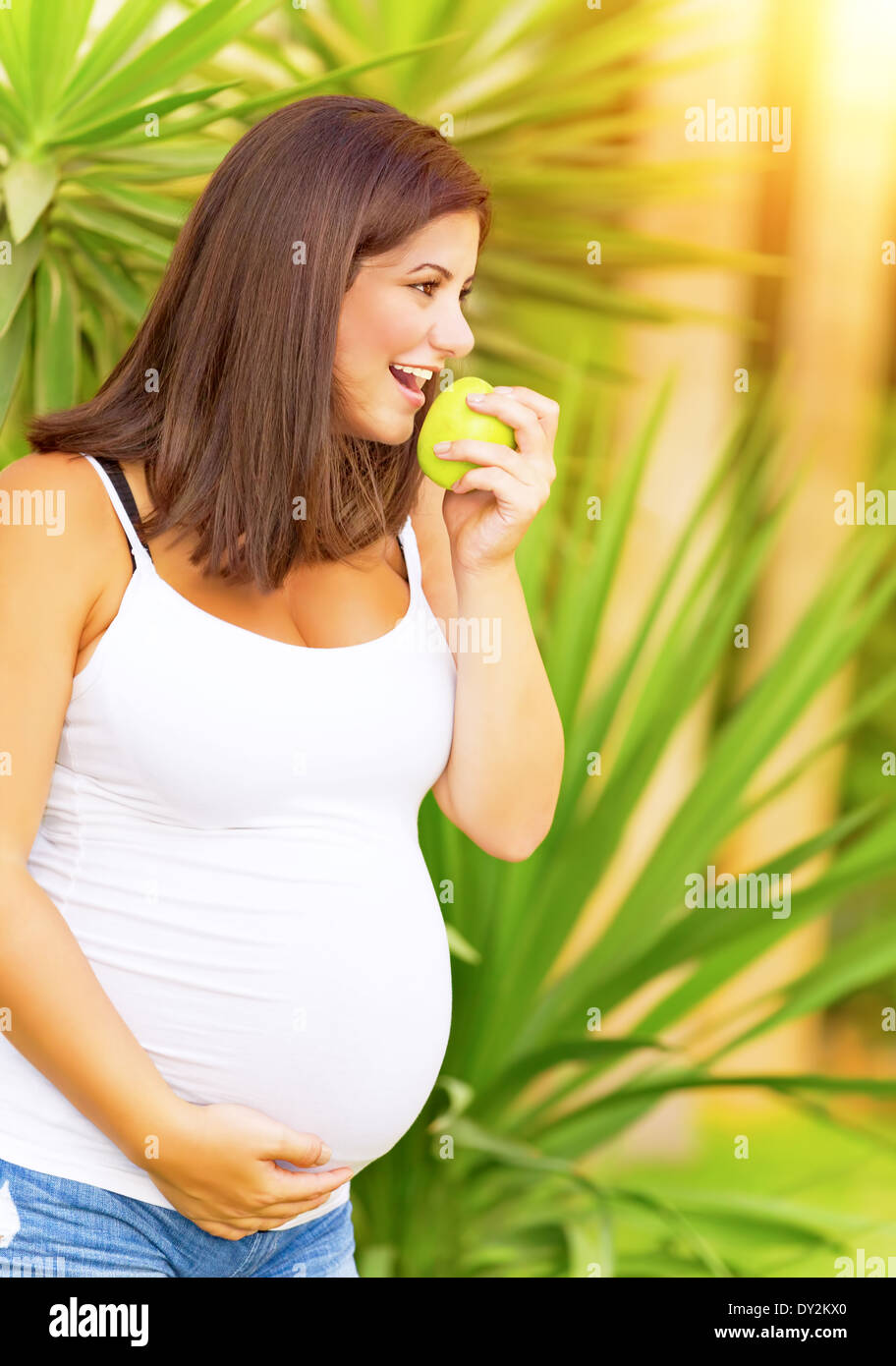 Portrait de femme enceinte belle bite, apple ayant l'amusement dans le parc exotique, passer du temps à l'extérieur, d'une saine alimentation Banque D'Images