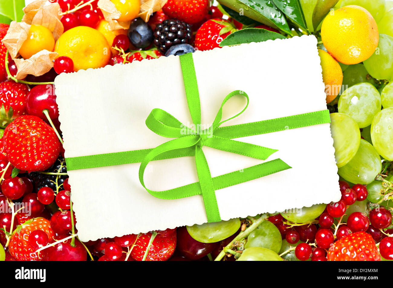 Carte-cadeau avec ruban vert avec des fruits et baies Banque D'Images