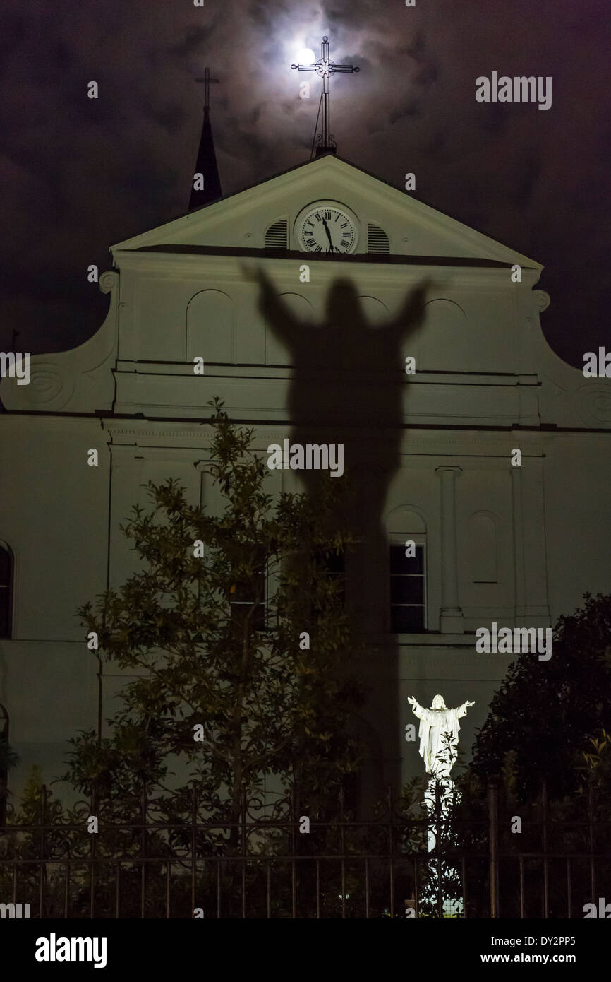 Pleine lune partiellement obstruée par une croix de fer et l'ombre d'une statue de Jésus à l'arrière de la Cathédrale Saint-Louis de La Nouvelle-Orléans Banque D'Images