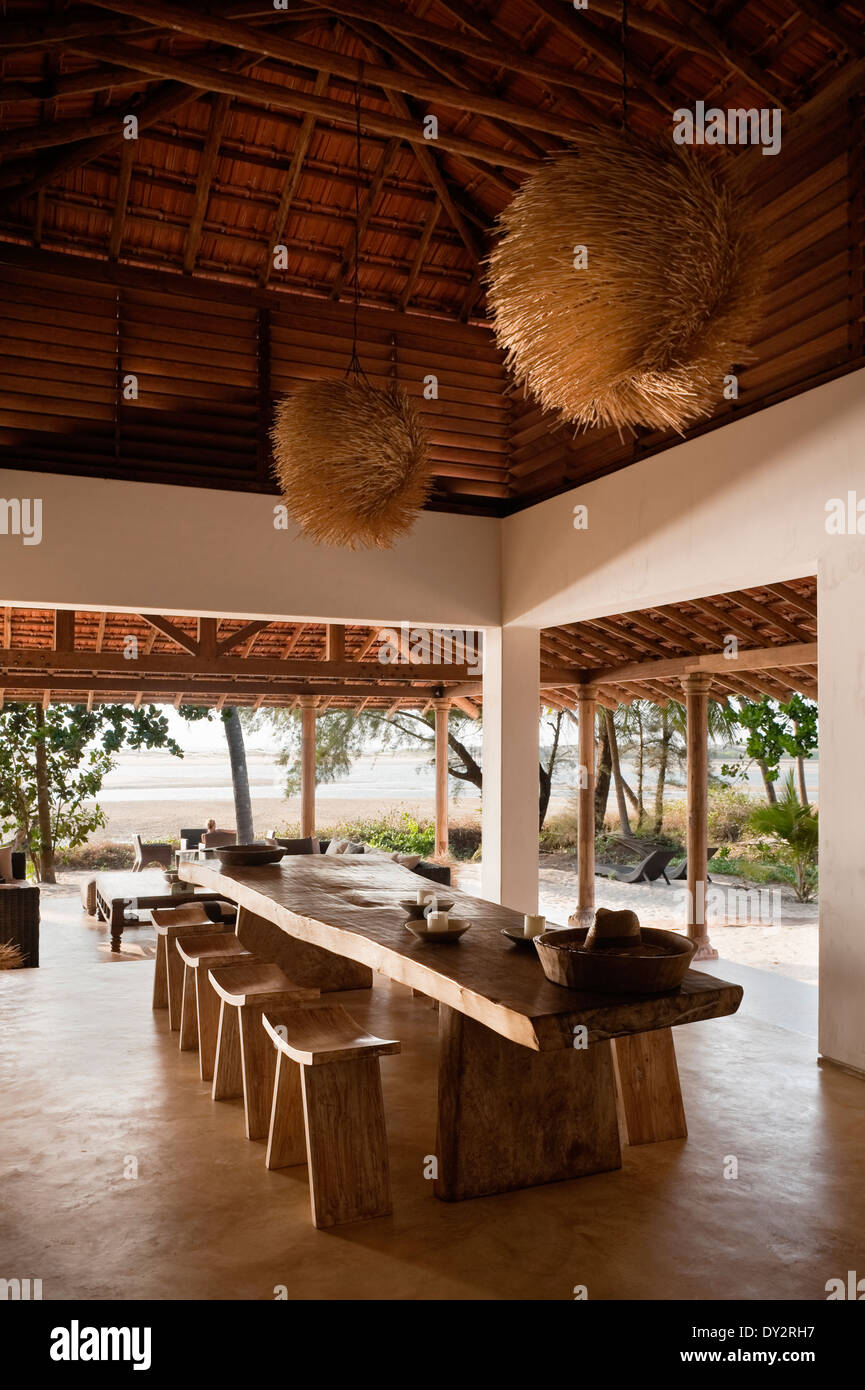 Salle à manger aux poutres apparentes avec abat-jour intérieur texturé en beach house retreat dans l'état de Goa Banque D'Images