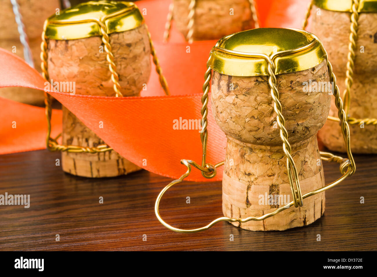 Libre de bouchons de champagne avec un ruban orange sur une table en bois Banque D'Images