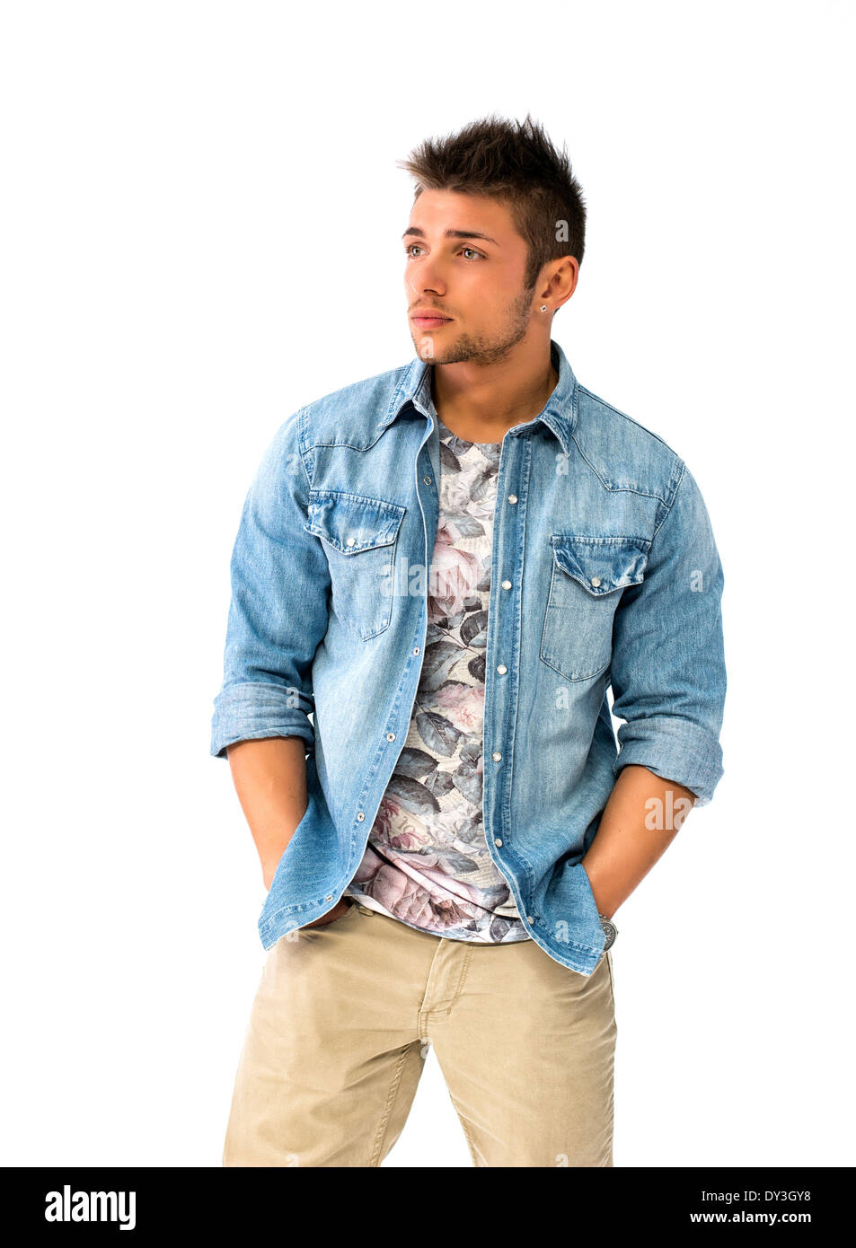 Beau jeune homme debout avec une chemise en jean, looking at camera, isolé Banque D'Images