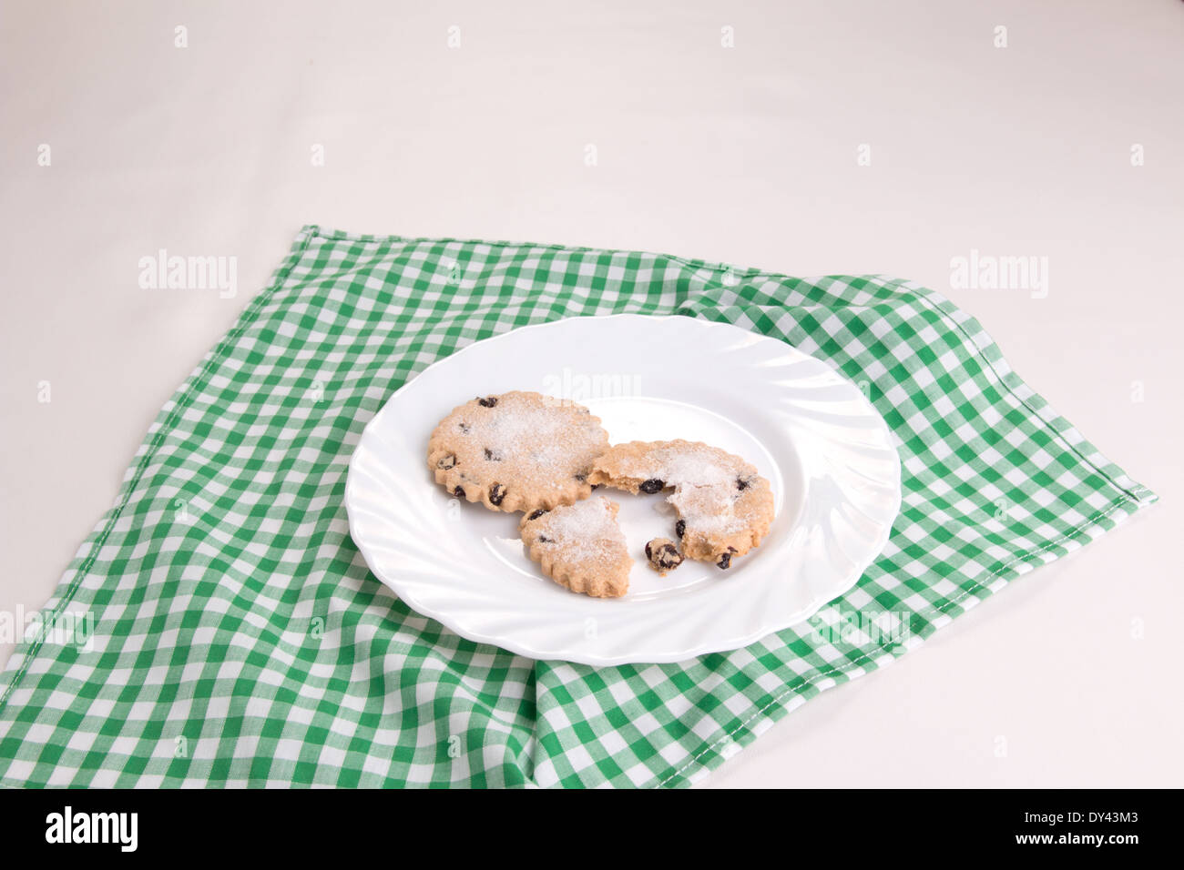 Garibaldi 2 biscuits fruits sur une assiette blanche situé sur une case verte et blanche chiffon avec un fond clair ( 6 d'une série de 17) Banque D'Images